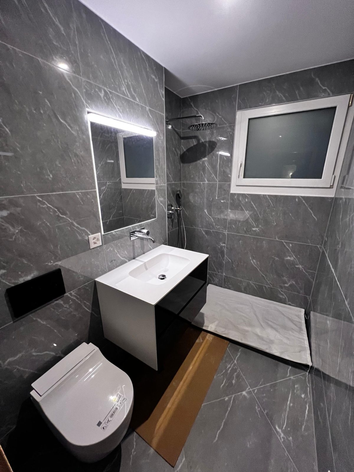 Salle de bain grise entièrement rénovée par AJ Sanitaire – Valais / Vaud