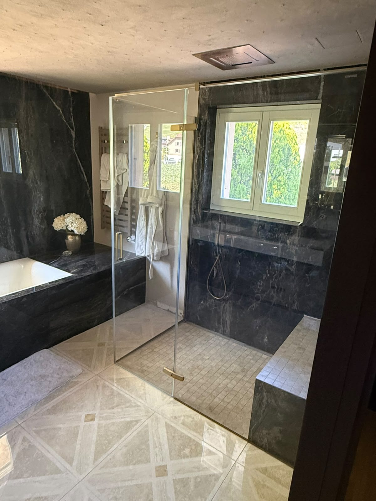 Salle de bain en marbre noir avec baignoire par AJ Sanitaire – Valais / Vaud