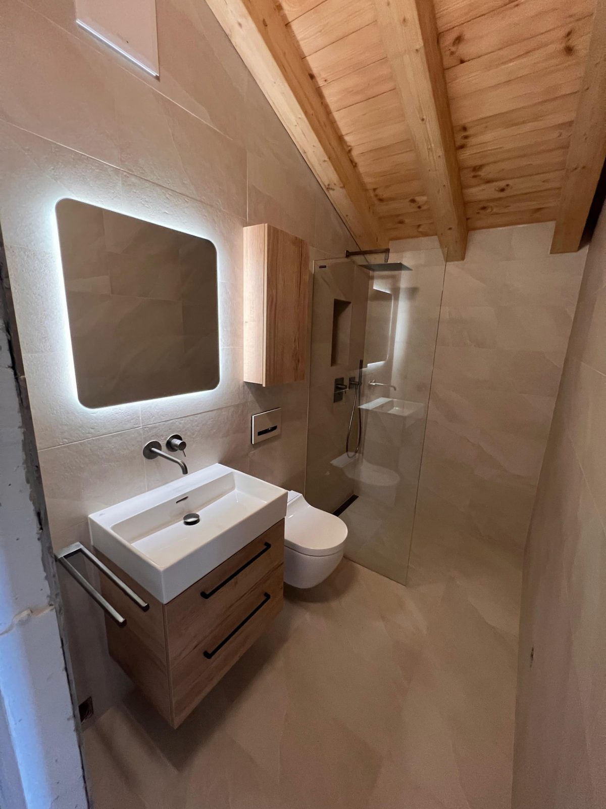 Salle de bain rénovée avec plafond en bois par AJ Sanitaire – Valais / Vaud